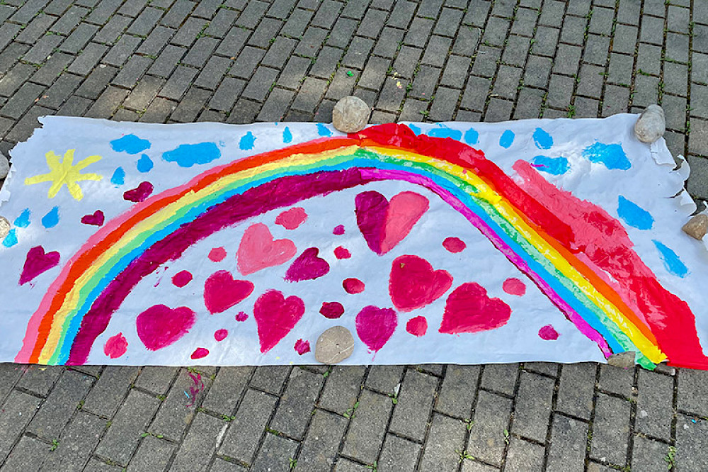 Bild zeigt einen Regenbogen, Herzen und eine Sonne.